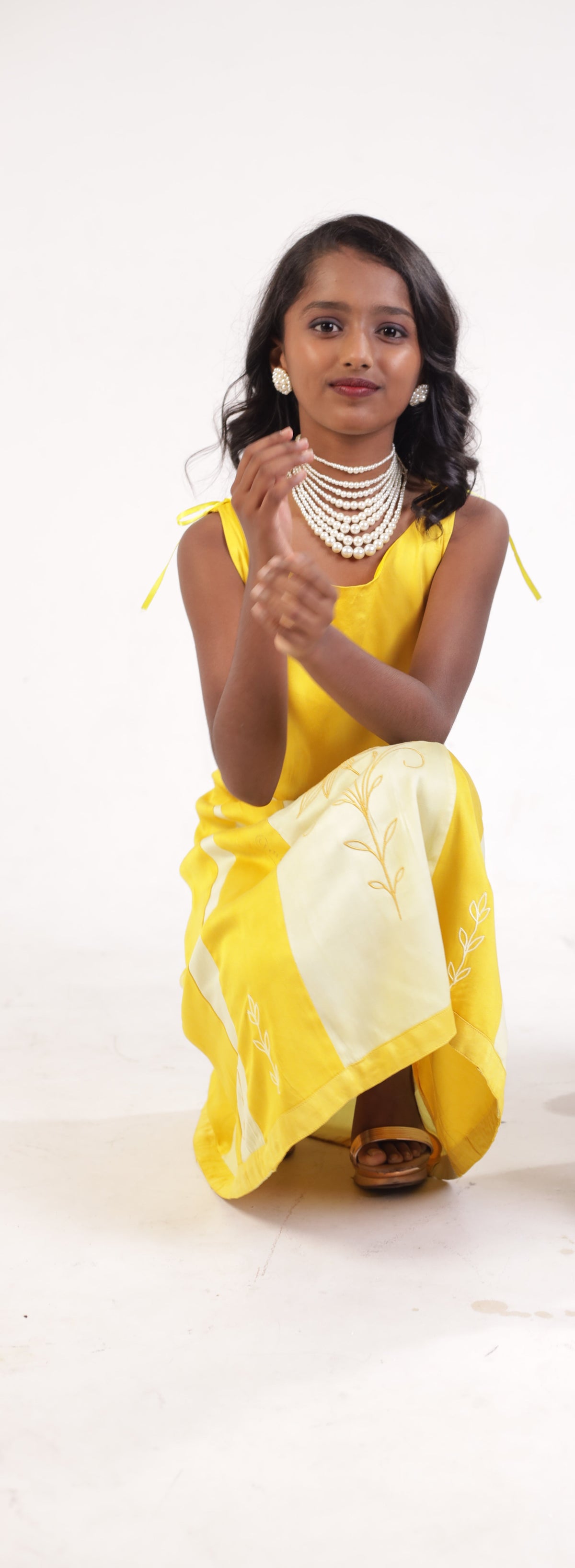 Yellow corn fibre frock shown seated, showing the fall of the cloth