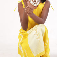 Yellow corn fibre frock shown seated, showing the fall of the cloth